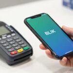 Płatność BLIKIEM w sklepie - osoba zbliżająca telefon do terminala płatniczego